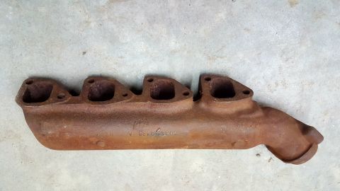 1973 Ford Mustang - A rusty exhaust manifold is shown, displaying some cast-in numbers on its side.