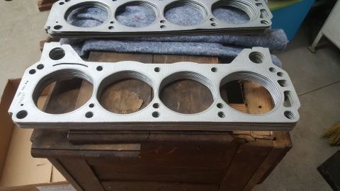 1973 Ford Mustang - Multiple engine head gaskets are stacked on a wooden surface, ready for installation.