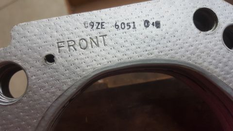 1973 Ford Mustang - A close-up view of a metal engine component displaying stamped identification numbers and the word 'FRONT'.