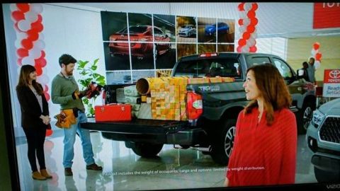 1971 Ford Ranchero - A truck bed is filled with boxes and a red toolbox, with people standing nearby in a showroom.