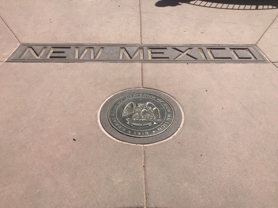 New Mexico state border marker on sidewalk