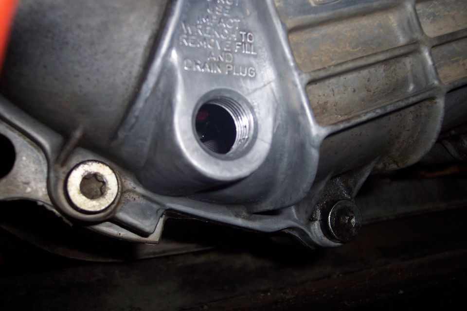 Close-up of a transmission/differential housing fill and drain plug area with text.