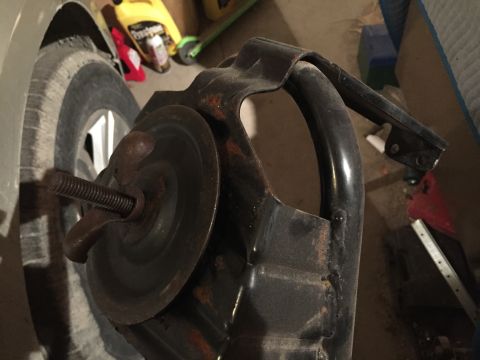 1967 Ford Custom Wagon - A close-up view of a rusty metal part with a threaded bolt and wingnut is shown in front of a car tire. The part appears to be a component…
