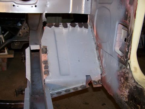 1965 Ford Mustang - This is a close-up, low-angle shot of the driver's side floor pan and rocker panel area of a classic car undergoing restoration. New metal…