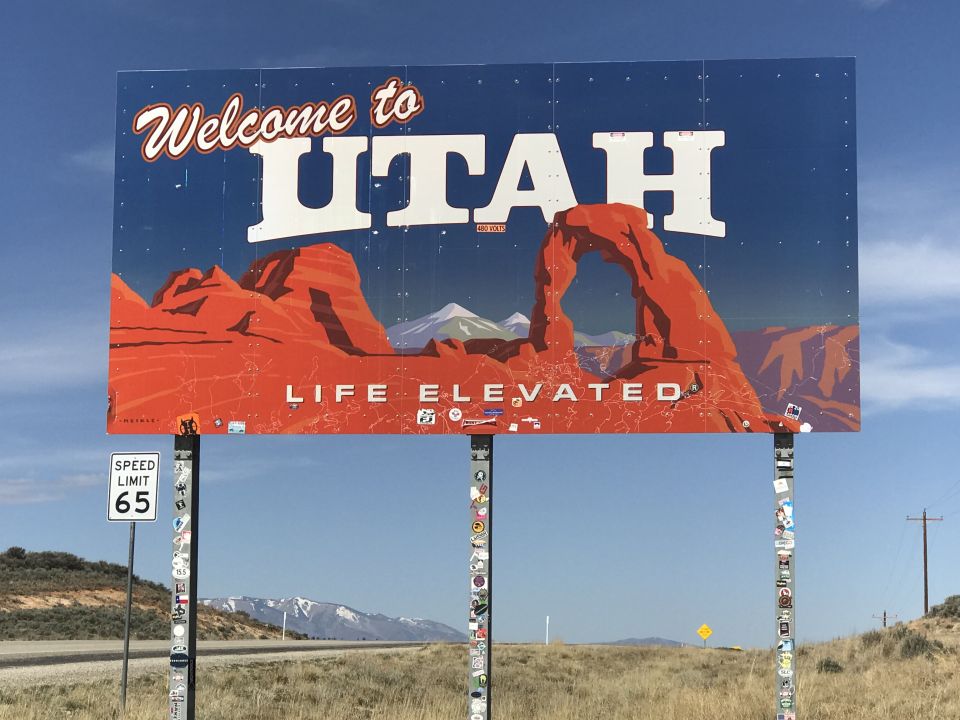 Welcome to Utah billboard with red rock formations and "LIFE ELEVATED" slogan.