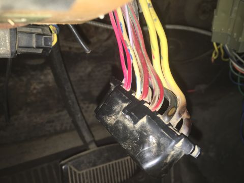 1980 Ford Bronco - A bundle of multi-colored wires, including yellow, red, and pink, are connected to a black plastic connector. Some of the wires appear to b…