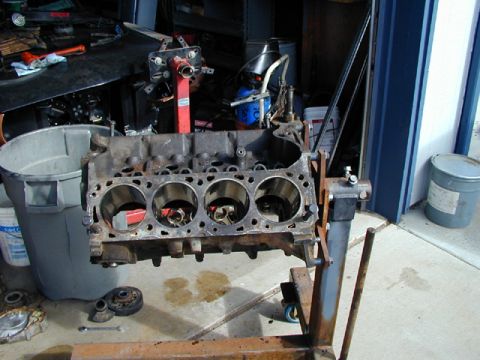 1979 Ford Bronco - An engine block is mounted on an engine stand, ready for work in a garage setting.