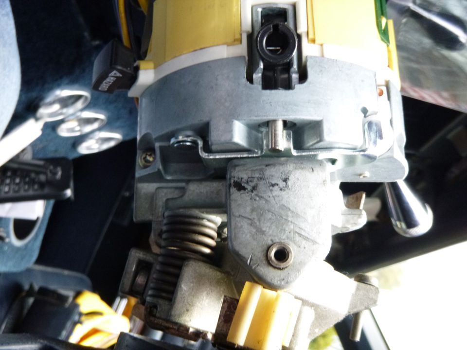 Close-up of a vehicle's ignition switch and steering column components.