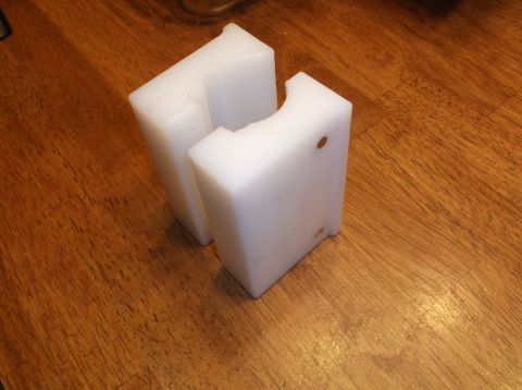 1995 Mercury Grand Marquis - Two white plastic blocks with cutouts are placed on a wooden surface.