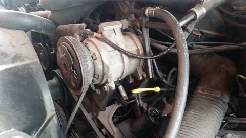 1985 Ford Bronco - The image shows a close-up view of the engine bay of a 1985 Ford Bronco, focusing on the air conditioning compressor and serpentine belt sy…