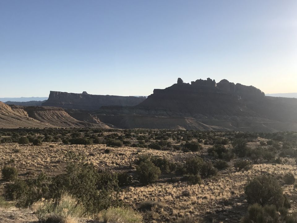 Desert landscape with mesas and sparse vegetation.