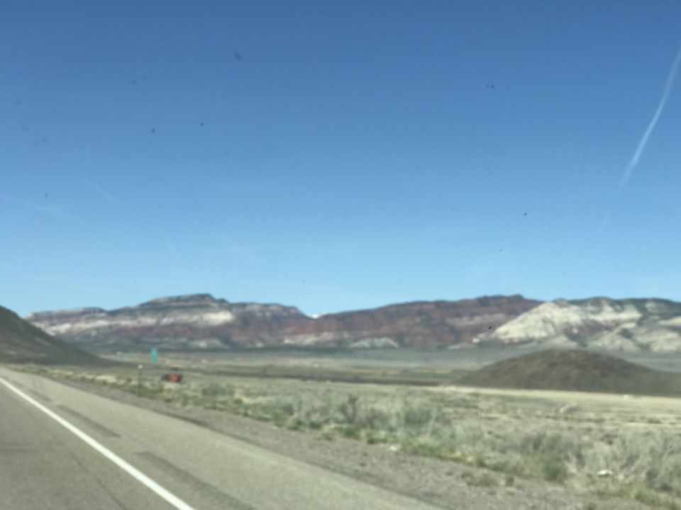 Desert landscape with layered mountains and a road.
