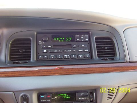 2002 Ford Crown Victoria - The interior of a car shows the dashboard with the radio and climate controls, along with a date stamp of 02/28/2004.