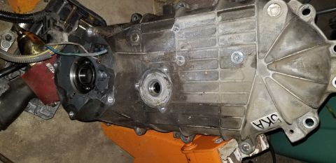 1995 Ford Bronco - Aluminum transfer case or gearbox housing with output bearing bore and gasket surface, marked DKA in white grease pencil.