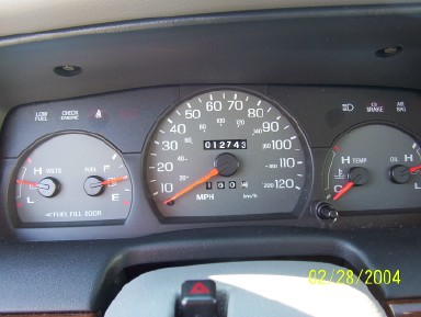 2002 Ford Crown Victoria - The dashboard of a vehicle displays various gauges, including the odometer reading 12,743 miles.