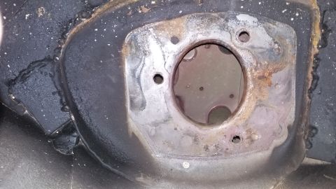 2000 Pontiac Grand Prix - This is a close-up view of a rusted metal mounting bracket with a circular opening in the center, likely part of a vehicle's suspension sys…