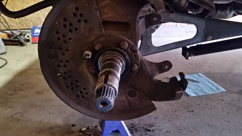 Once the hub is gone, and the brake caliper is removed, take your 4-prong socket and remove the nuts holding the wheel bearings in.  There is an outer nut, a washer with a bunch of holes in it, and another 4-prong nut behind it.  Once these are removed the entire hub assembly off.  This is what's left.