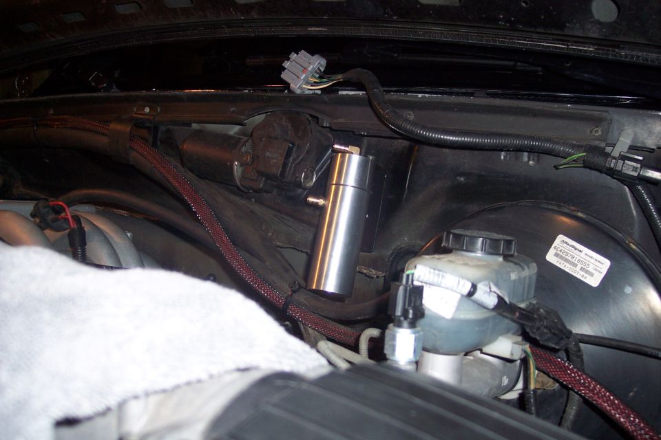 Custom oil catch can and brake fluid reservoir under the hood of a 1995 Ford Bronco.