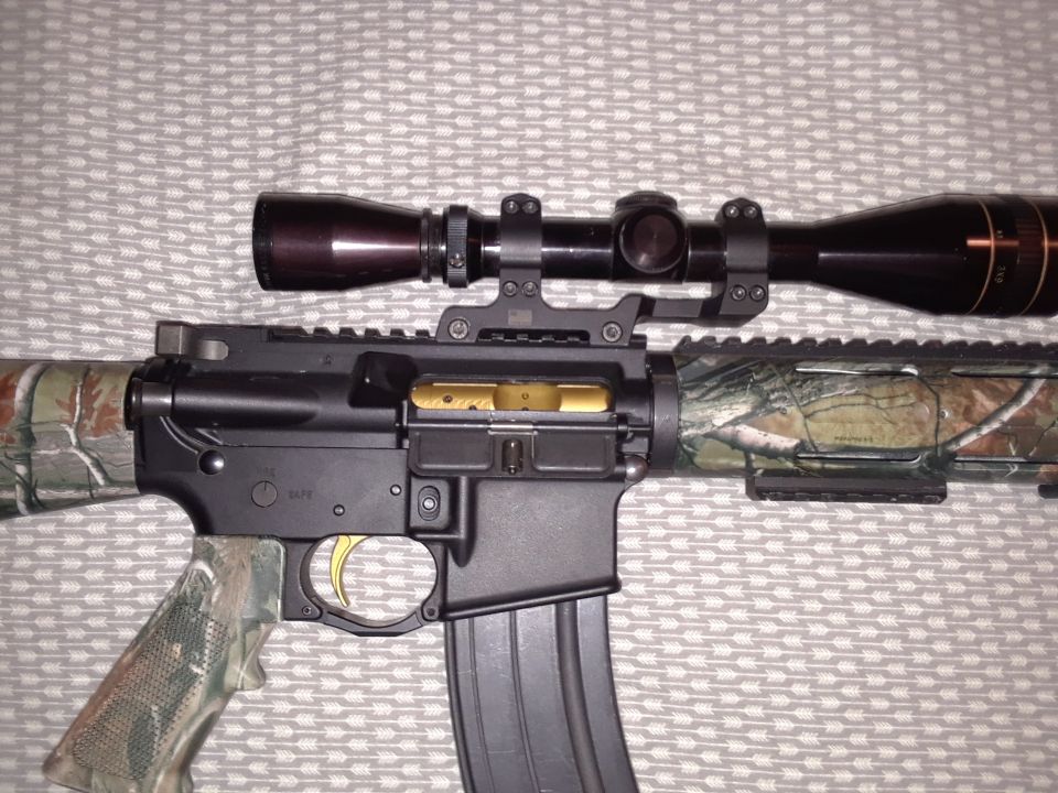 Rifle with scope, camouflage stock, and gold trigger