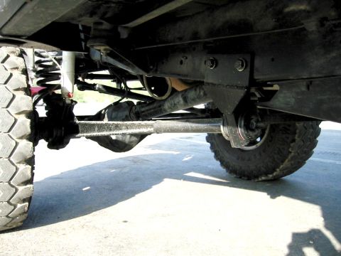 1985 Ford Bronco - The underside of a vehicle is captured, highlighting its heavy-duty suspension and drivetrain.