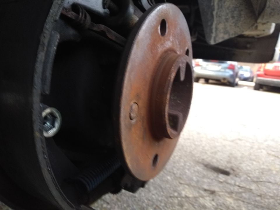Rusted brake rotor and hub assembly with visible brake drum components