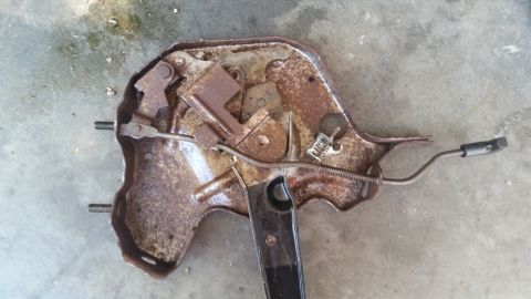 1985 Ford Bronco - This is a rusted seat adjustment mechanism with a black lever and cable attached.