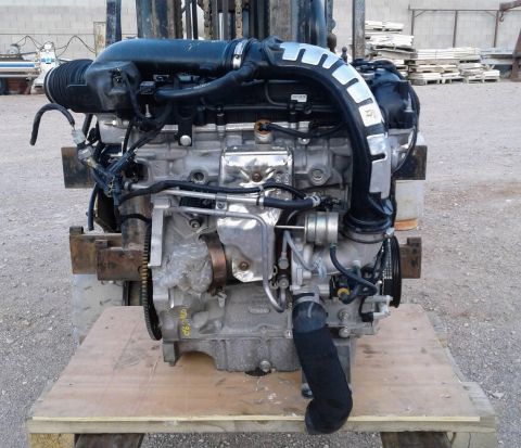 1995 Peterbilt 379 - Engine assembly with various hoses and electrical connections, displayed outdoors on a wooden pallet.