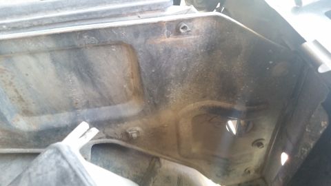 1985 Ford Bronco - This photo shows the underside of a vehicle's hood, revealing structural components and fasteners.