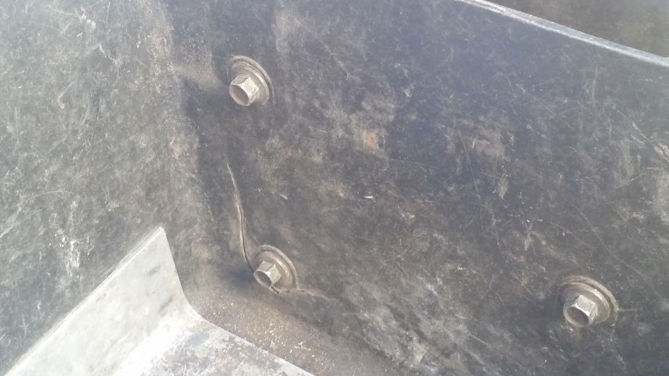 Black plastic underhood toolbox with three visible bolts and scratches