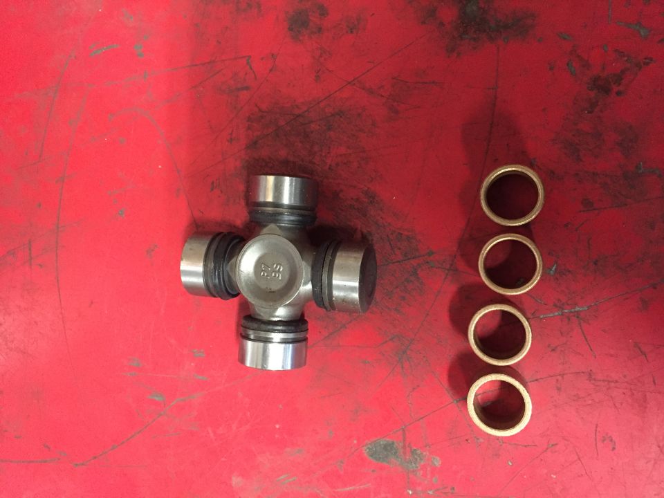 Universal joint with four bearing races on a red surface