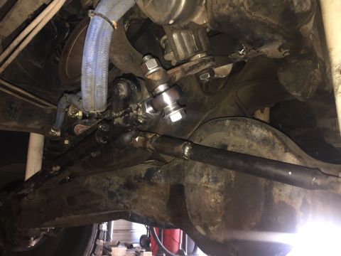 1984 Ford Bronco - Underside view of a vehicle's steering and suspension system, showing various metal parts and hoses.