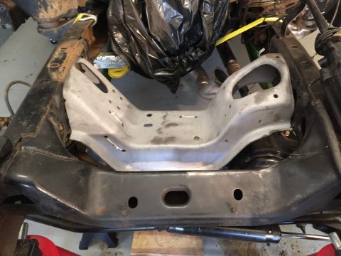 1979 Ford Bronco - A close-up, overhead view of a vehicle's frame with a silver metal bracket installed in the center. The frame appears to be from a truck or…