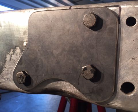 1979 Ford Bronco - A close-up view shows a custom fabricated steel plate bolted to the frame of a vehicle. The plate has a curved lower edge and is secured by…