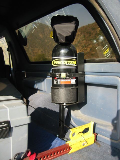 1985 Ford Bronco - A Powertank air compressor system is mounted inside a vehicle, alongside recovery gear and storage.