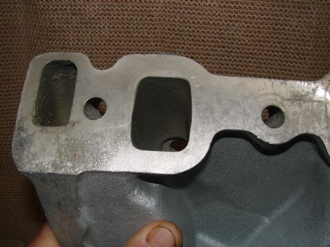 1973 Ford Ranchero - A close-up view of a cast aluminum intake manifold with two intake ports visible. The manifold is dark gray on the bottom and silver on the…