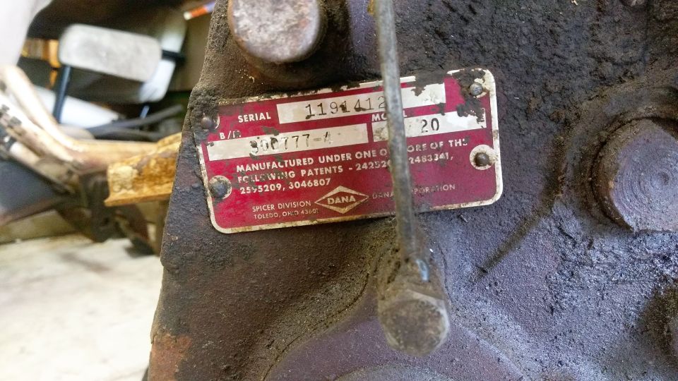Red Dana Spicer ID tag on rusty housing showing serial 1191412 and Model 20