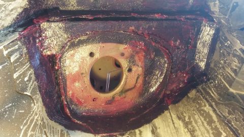 2000 Pontiac Grand Prix - A close-up view shows a metal component, likely part of a vehicle's undercarriage, coated in a thick, dark red grease. The component has a…