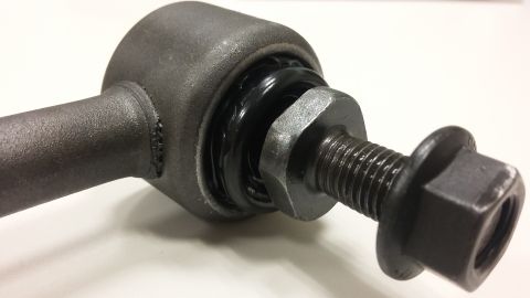 2000 Pontiac Grand Prix - A close-up, angled shot shows a metal automotive suspension part, likely a sway bar end link, with a black rubber bushing and a bolt with a…