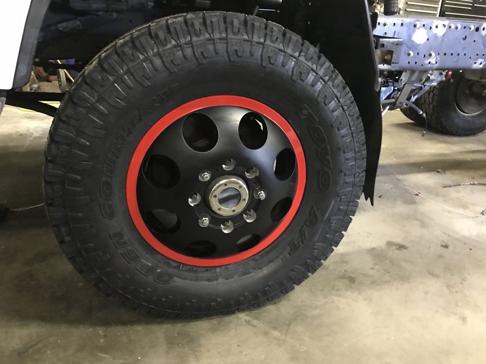 Truck wheel with red accent ring and Toyo Open Country A/T tire.
