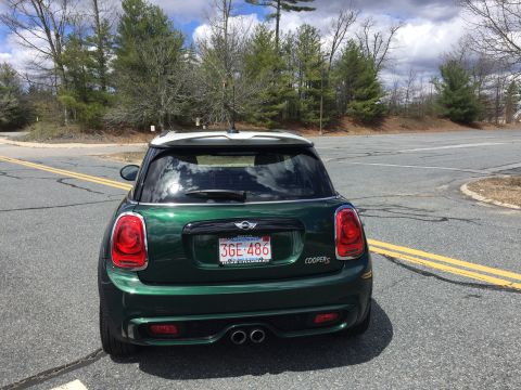 2001 Ford Crown Victoria - The rear view of a dark green Mini Cooper S parked on a paved road with double yellow lines. The license plate reads "3GE 486".