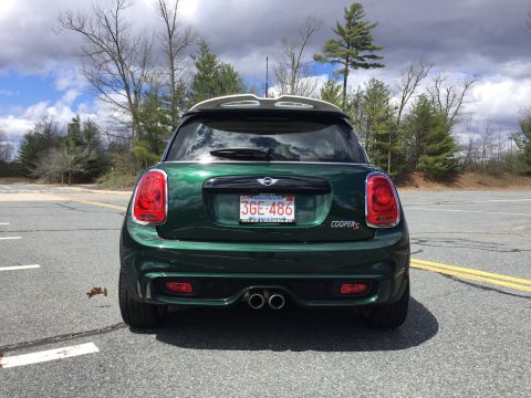 2001 Ford Crown Victoria - The rear view of a dark green Mini Cooper S is shown parked on an asphalt surface with yellow lane markings. The car has a Massachusetts li…