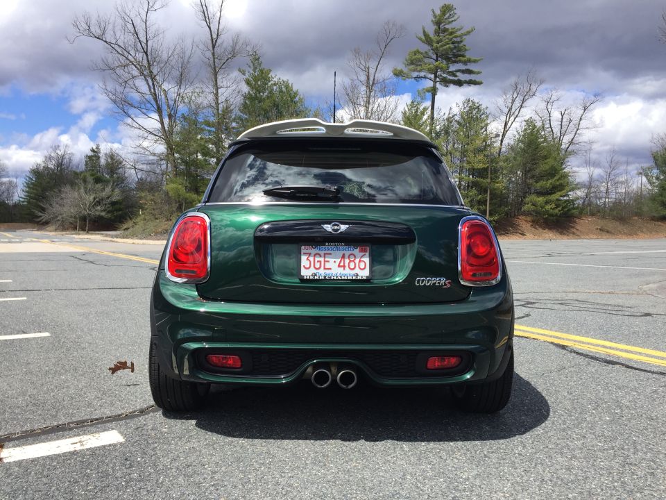 Rear view of a dark green Mini Cooper S with a Massachusetts license plate.
