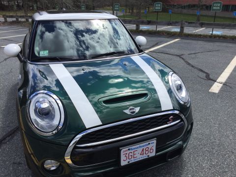 2001 Ford Crown Victoria - A dark green Mini Cooper S is parked in a lot, showing its front end with white racing stripes on the hood and a Massachusetts license plat…