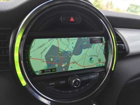 2001 Ford Crown Victoria - The interior of a car shows a circular infotainment screen displaying a GPS map. The screen is surrounded by a chrome bezel with green acce…