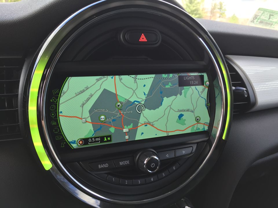 Car infotainment screen showing GPS map with chrome bezel and green accent lighting.