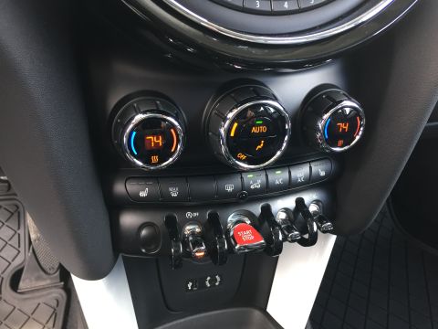 2001 Ford Crown Victoria - The interior of a car shows the center console with climate control knobs and buttons. A red "START ENGINE STOP" button is visible.