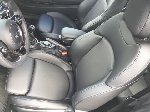2001 Ford Crown Victoria - The interior of a car shows black leather seats, a steering wheel with controls, and a manual gear shifter. The driver's seat is in the for…