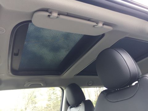 2001 Ford Crown Victoria - The interior of a car shows a dual-pane sunroof with the sunshade partially open, revealing the sky. A sun visor is visible above the sunro…