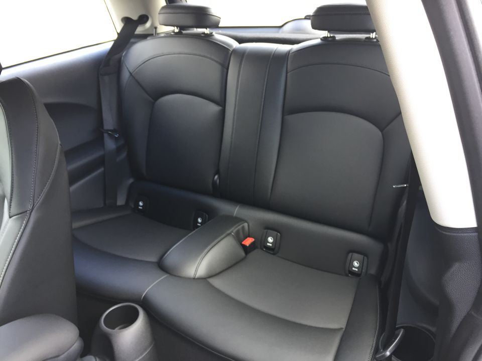 Black leather rear car seats with ISOFIX anchors and seat belts.