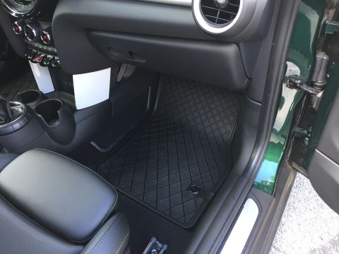2001 Ford Crown Victoria - Interior view of the passenger side footwell and dashboard of a dark green vehicle. A black diamond-patterned floor mat covers the floor, a…